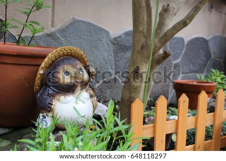 Raccoon statue in a little garden