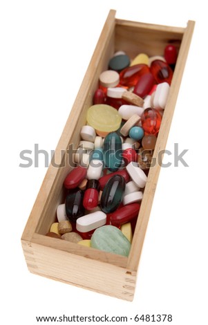 Assorted pills in box over white