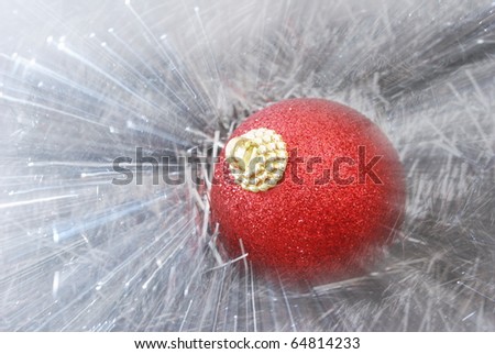 Abstract view of red christmas ball on bright silver tinsel