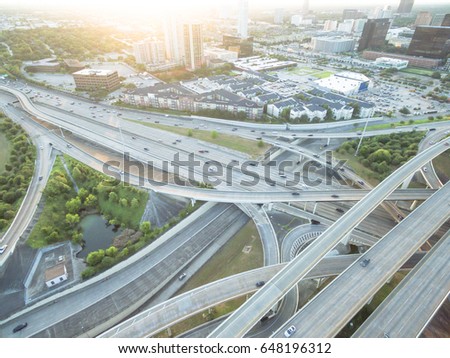 Aerial Interstate I-610 freeway with massive intersection, stack interchange, elevated road junction overpass and building. Nightly degree vertical view metropolitan area of mid-town Houston, Texas,US