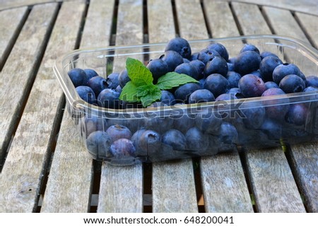Blueberries in a plastic box on a wooden table