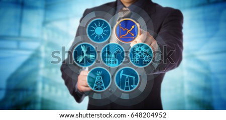 Blue chip manager monitoring energy efficiency via a virtual control interface. Industry concept for efficient energy use, sustainability reporting, audit and rise in renewable power generation. Royalty-Free Stock Photo #648204952