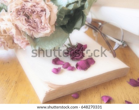 The dried roses of bright soft focus on the blur old book