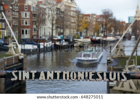 A boat passing under the Sint Anthoniesluis bridge in Amsterdam, Netherlands