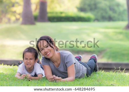 Happy mother and son on the lawn in the garden
