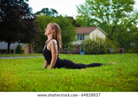Young girl doing yoga exercise alone on the lawn