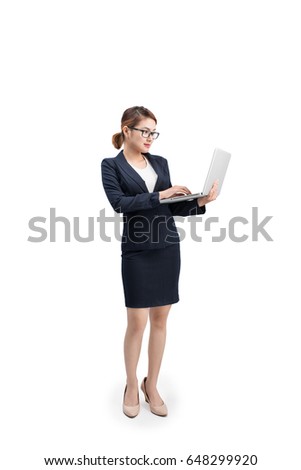 Full length of a young female businesswoman holding laptop over grey background.