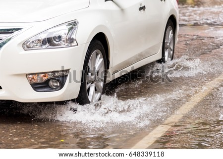 blur picture of Wheels ran over the water, Car driving on a flooded road Royalty-Free Stock Photo #648339118