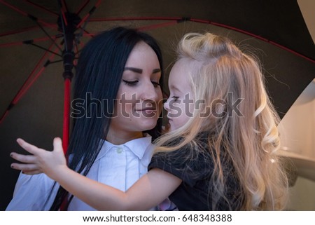 Small girl and mom in exhibition hall for car