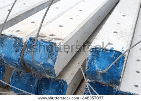 Group of concrete electricity poles stacked on floor close up 