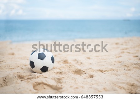 Soccer ball on sandy beach after game