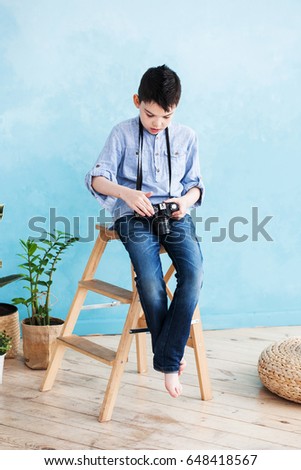 A boy with a camera looks down