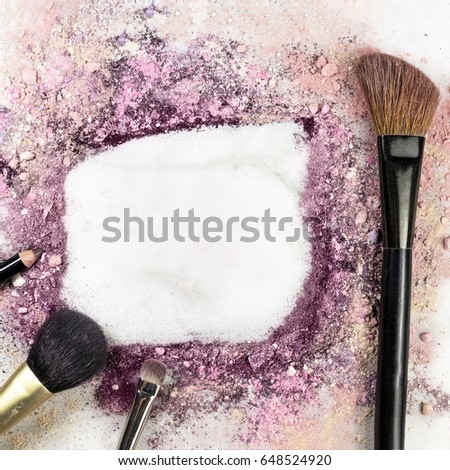 Makeup brushes and pencil on white marble background, with traces of powder and blush forming a frame. A square template for a makeup artist's business card or flyer design, with copy space