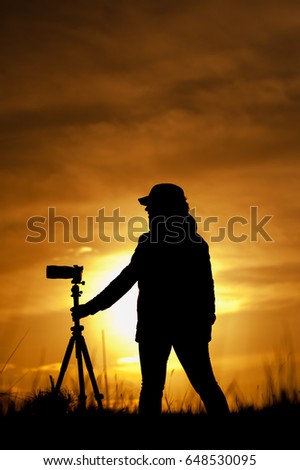 Female photographer with camera at sunsetlight
