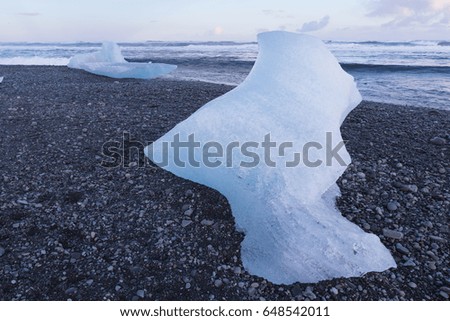Ice breaking on black sand beach, natural winter Iceland landscape background