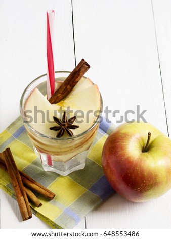 Detox water with apple, cinnamon and anise on a white wooden background