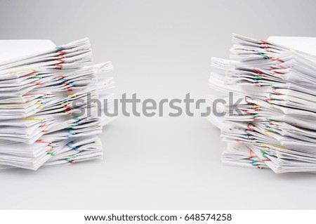 Dual pile overload document report of sales and receipt with colorful paper clip as work messy is going to be successful place on table with white background. Business and finance concept photography.