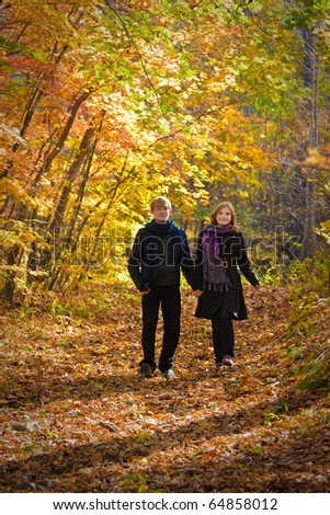 Active beautiful boy and girl in autumn wood