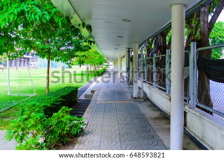 The walkway beside the football field inside the school.