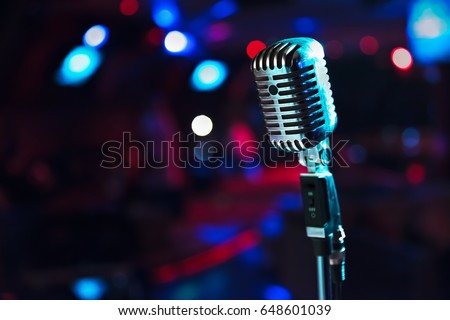 Retro microphone against blur colorful light restaurant background Royalty-Free Stock Photo #648601039
