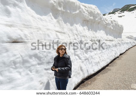Female traveler and snow wall at japan alps tateyama kurobe alpine route