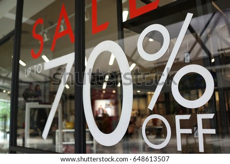 Large Sale 70% off letters on a glass wall obstruct a view inside the popular clothing store Royalty-Free Stock Photo #648613507