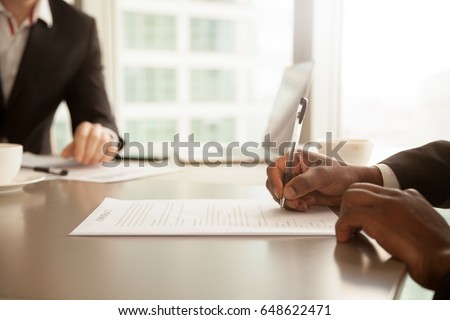 Afro american businessman signing partnership agreement concept, focus on male hand putting signature, concluding official contract on meeting, african entrepreneur making profitable deal, close up Royalty-Free Stock Photo #648622471