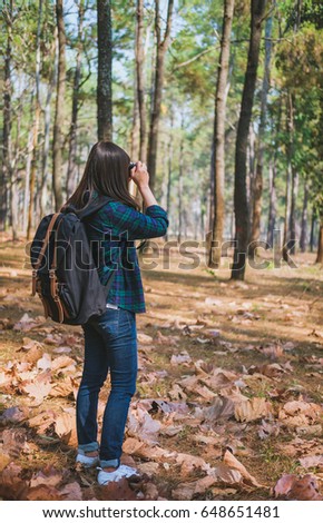 Hipster young women with backpack taking photo in the park , Tourist traveler and vacation concept.