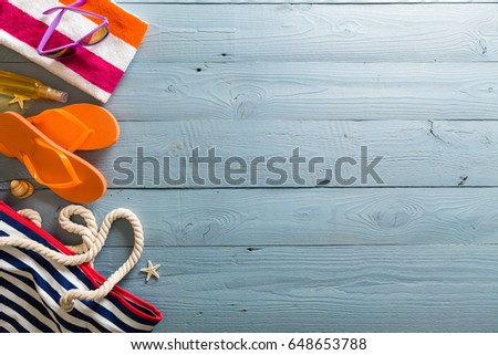 Summer vacation background theme with seashells, bag, hat, sunglasses and blue wood background with copy space. Top view.