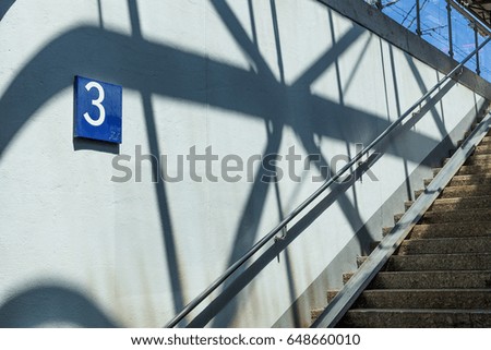 Underground crossing at the station, stairs and signs with different numbers.