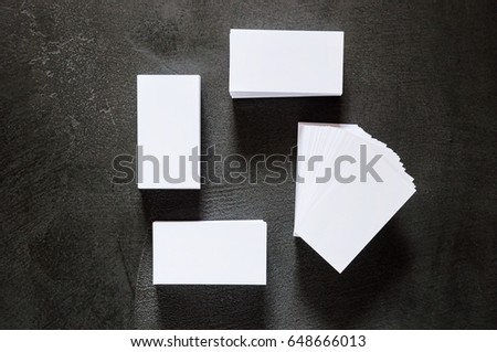 Business cards on a black background of stone table texture. Layout for branding. Sample for corporate identity. Template for graphic designers of presentations and portfolio. View from above.