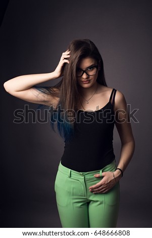 Beautiful brunette girl in glasses and green pants