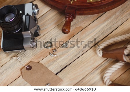 Camera and maritime decorations on the wooden background, top view
