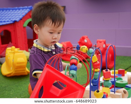 a toddler boy playing logic toys in kids zone