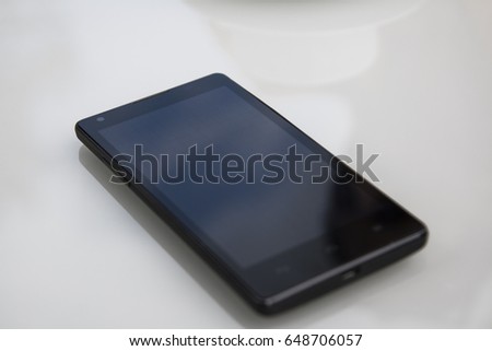 Black phone on white table