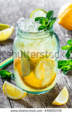 Fresh lemonade with mint, lemon and ice in glass jar on wooden background. Summer drinks and cocktails