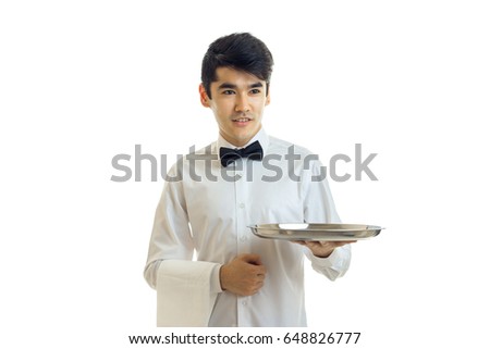 handsome young waiter stretches forward tray in hand