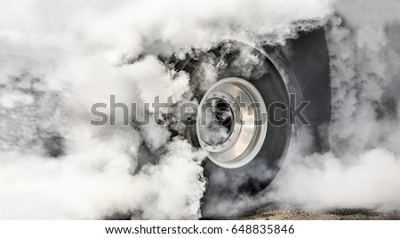 Drag racing car burns rubber off its tires in preparation for th Royalty-Free Stock Photo #648835846