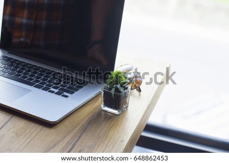 Laptop small eyeglasses are on the side of the window.