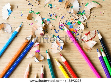 Colorful color Pencils with shavings on the wood table.