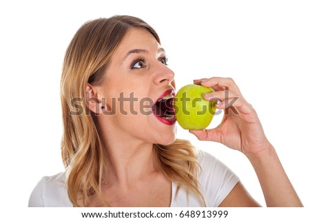Picture of a beautiful young girl on diet holding a fresh green apple, posing on isolated background