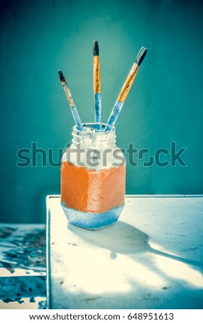 Brushes for painting stand with bristles up in a glass