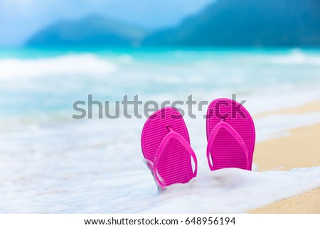 Beach holiday. Pair of slippers on a sandy beach in Hawaii. 