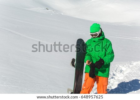 snowboarder snowboarding on fresh white snow with ski slope on Sunny winter day