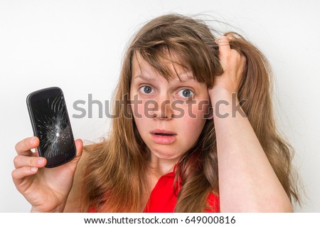Sad woman is holding smartphone in her hand with broken screen