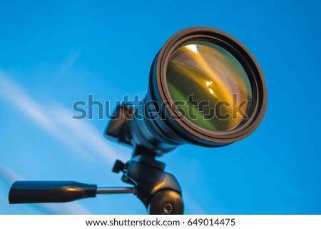 The camera with a tripod on the blue sky background
