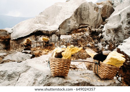 Baskets with sulfur in the crater Ijen Volcano, East Java, Indonesia. Dangerous work and place.