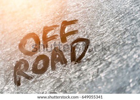 Inscription OFF ROAD on a dirty metal surface with glow