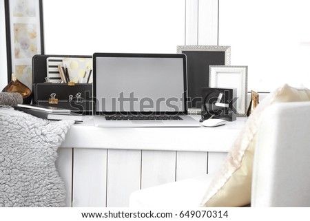 Creative workplace with laptop on windowsill in modern room