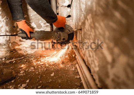 Worker cuts a metal pipe with sparks